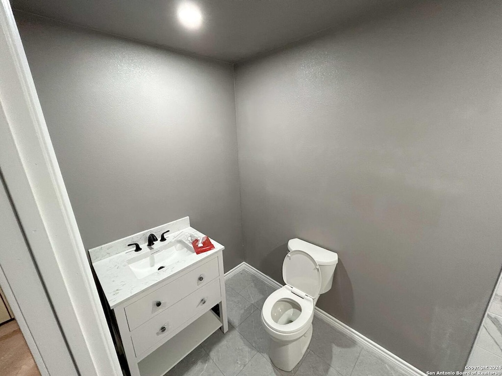 bathroom with tile patterned flooring, vanity, and toilet