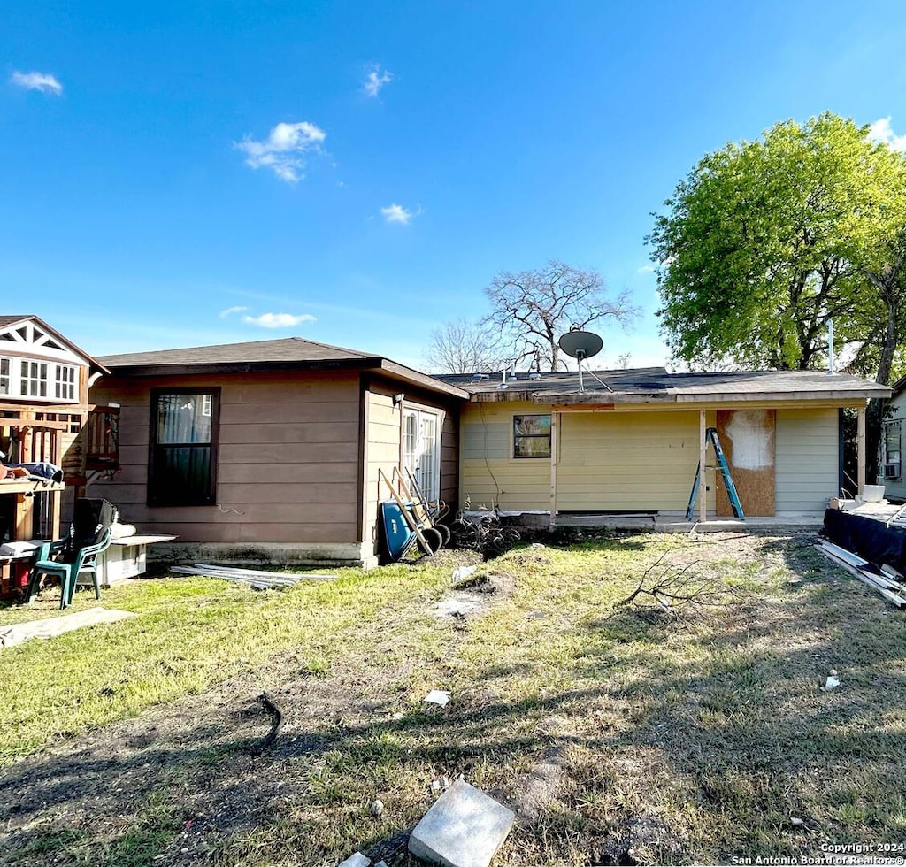 rear view of property featuring a yard