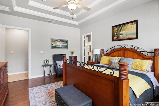 bedroom with a raised ceiling, ceiling fan, dark hardwood / wood-style floors, and ornamental molding