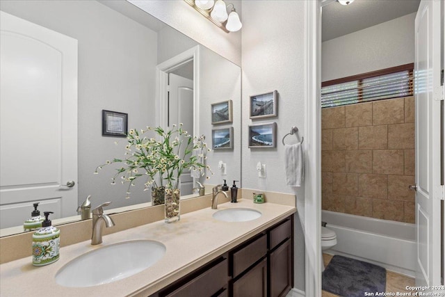 full bathroom with tiled shower / bath, tile patterned flooring, vanity, and toilet