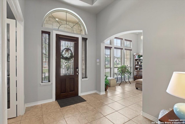 entrance foyer featuring a towering ceiling and light tile patterned floors