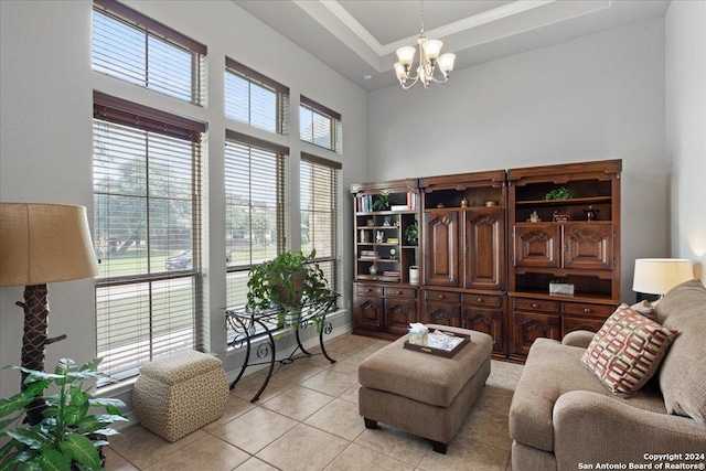 interior space with a raised ceiling, crown molding, a high ceiling, and an inviting chandelier