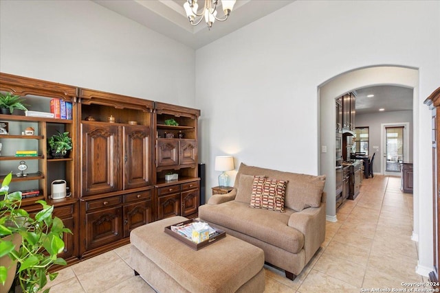 tiled living room with high vaulted ceiling and a notable chandelier