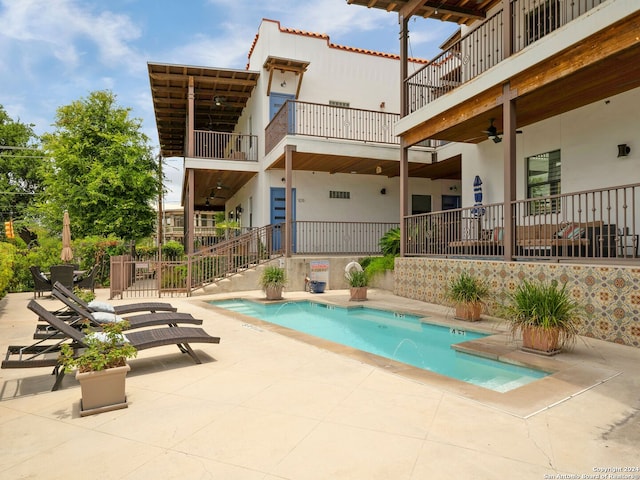 view of swimming pool with pool water feature, ceiling fan, and a patio area