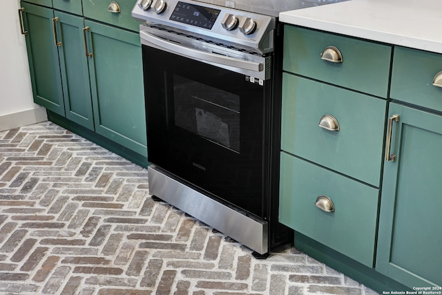 interior details with electric stove and green cabinets