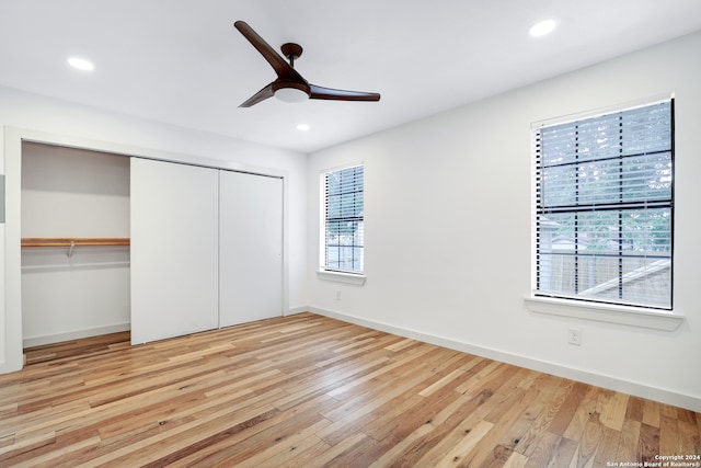 unfurnished bedroom featuring ceiling fan, a closet, and light wood-type flooring