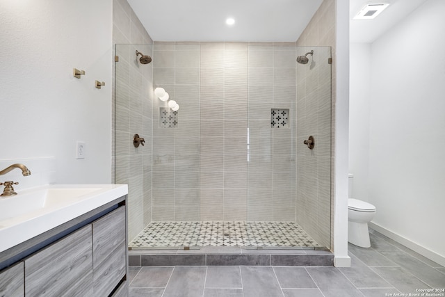 bathroom with a tile shower, tile flooring, toilet, and vanity