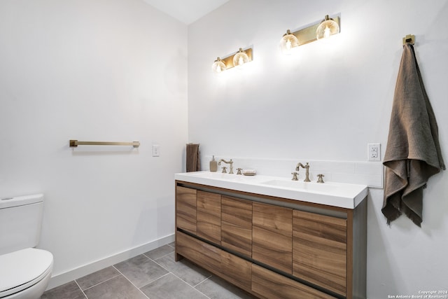 bathroom featuring tile floors, toilet, and dual bowl vanity