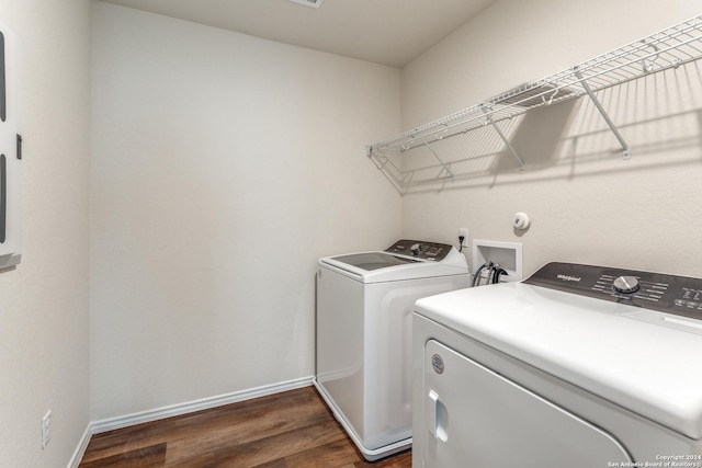 laundry area with dark hardwood / wood-style floors and washing machine and clothes dryer