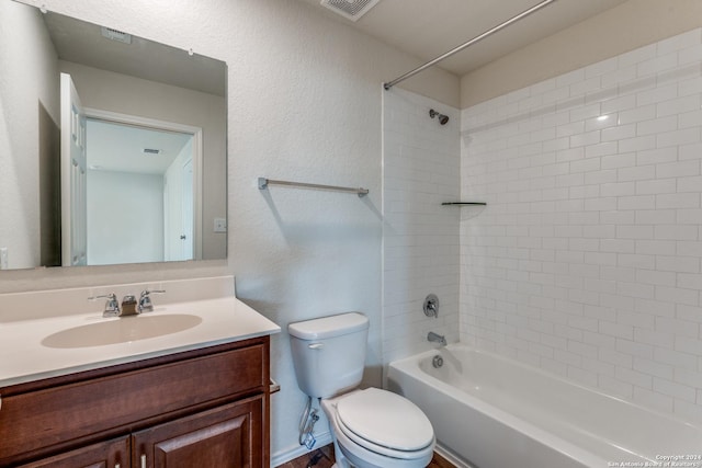 full bathroom with tiled shower / bath, vanity, and toilet