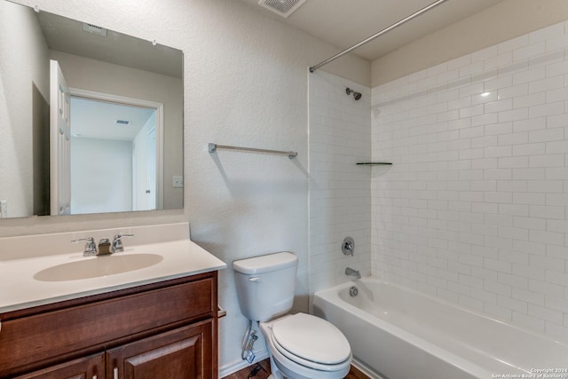 full bathroom with vanity, tiled shower / bath combo, and toilet