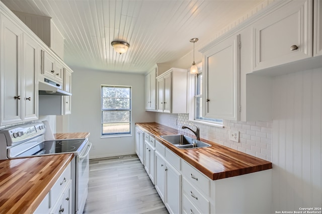 kitchen featuring pendant lighting, electric range, sink, and wooden counters