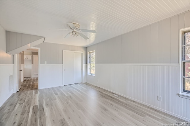 unfurnished room with ceiling fan, lofted ceiling, and light wood-type flooring