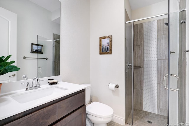 bathroom featuring vanity, an enclosed shower, and toilet