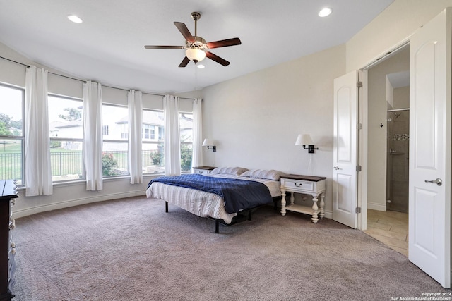 carpeted bedroom featuring multiple windows and ceiling fan