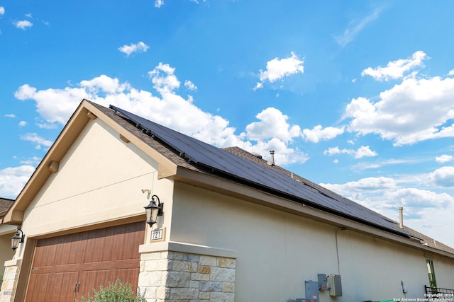 view of side of property with solar panels and a garage