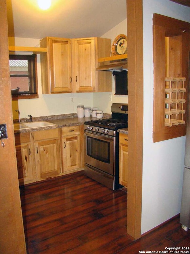 kitchen featuring sink, wall chimney range hood, dark hardwood / wood-style flooring, and stainless steel range with gas stovetop