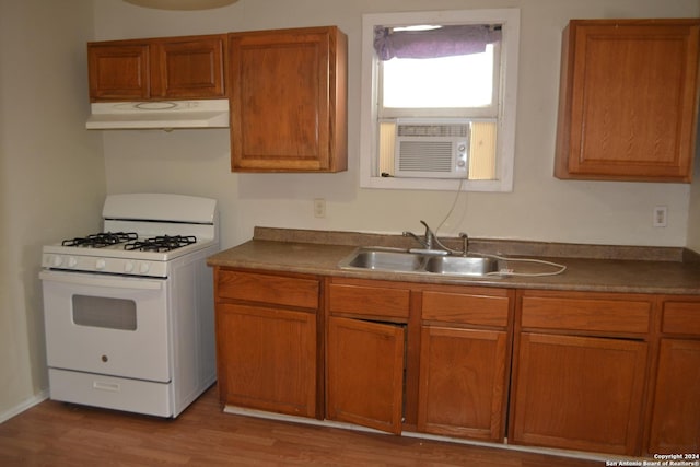 kitchen featuring white gas range, sink, cooling unit, and light hardwood / wood-style floors