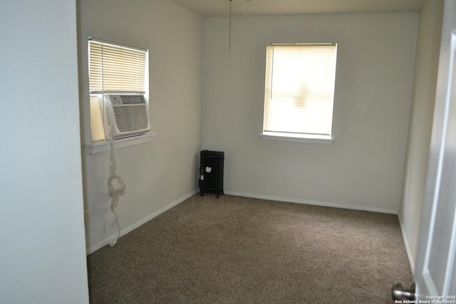 spare room featuring radiator, carpet floors, and cooling unit