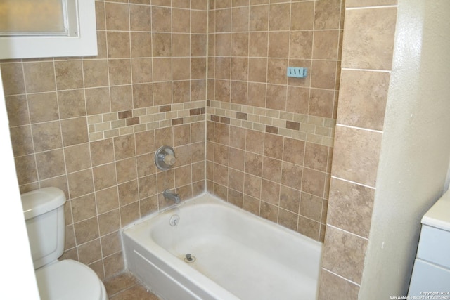 bathroom with tiled shower / bath combo and toilet