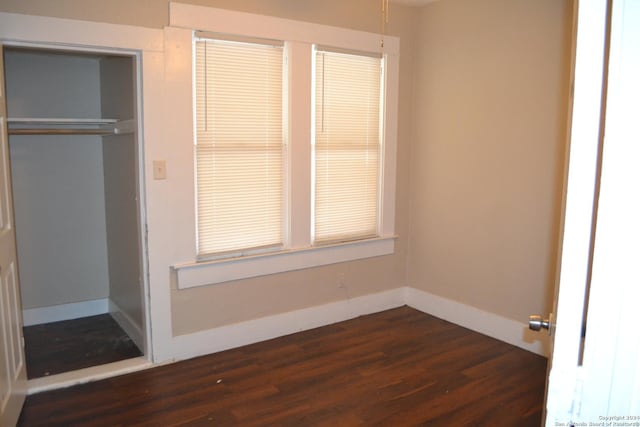 unfurnished bedroom featuring a closet and dark hardwood / wood-style floors