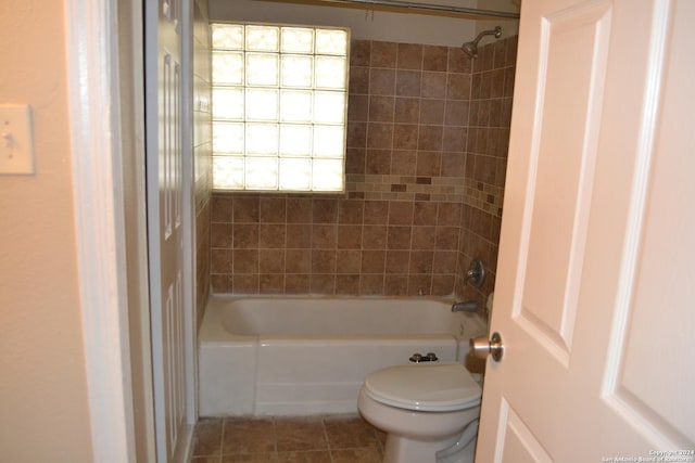 bathroom featuring tile patterned floors, tiled shower / bath combo, and toilet