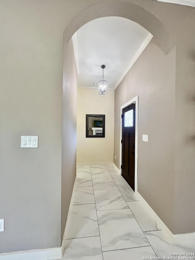 corridor with a chandelier and ornamental molding