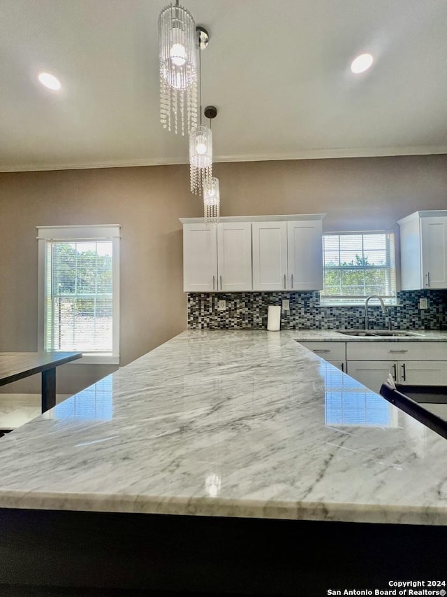 kitchen featuring pendant lighting, white cabinetry, and plenty of natural light