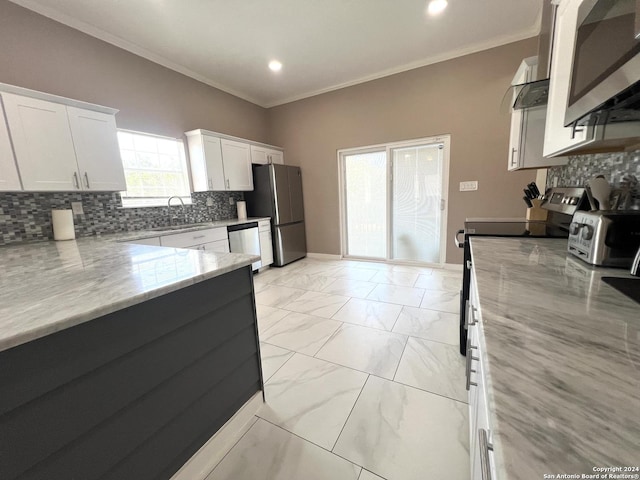 kitchen with white cabinets, light stone counters, sink, and appliances with stainless steel finishes