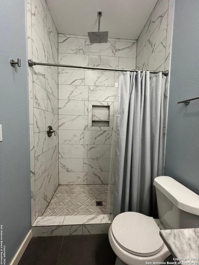 bathroom with a shower with shower curtain and toilet