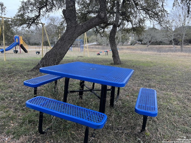 view of property's community with a lawn and playground community