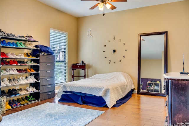 bedroom featuring baseboards, multiple windows, a ceiling fan, and light wood-style floors