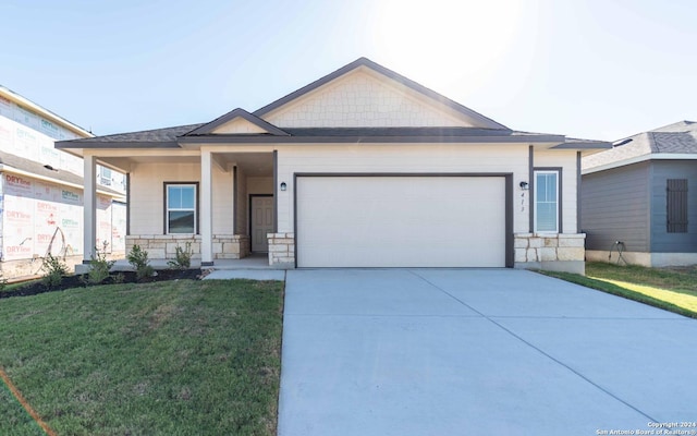 single story home featuring a garage, a front yard, stone siding, and driveway