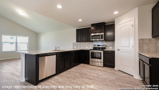 kitchen featuring kitchen peninsula, light hardwood / wood-style floors, vaulted ceiling, and appliances with stainless steel finishes