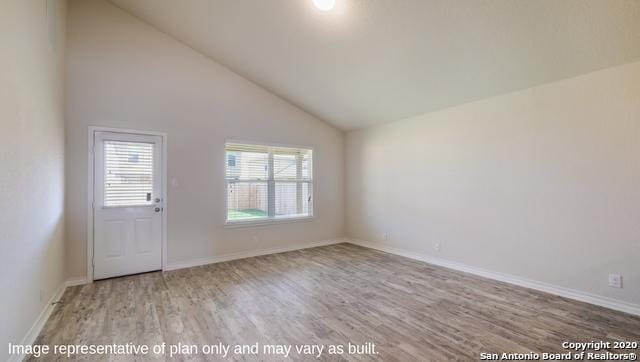 empty room with hardwood / wood-style flooring and high vaulted ceiling