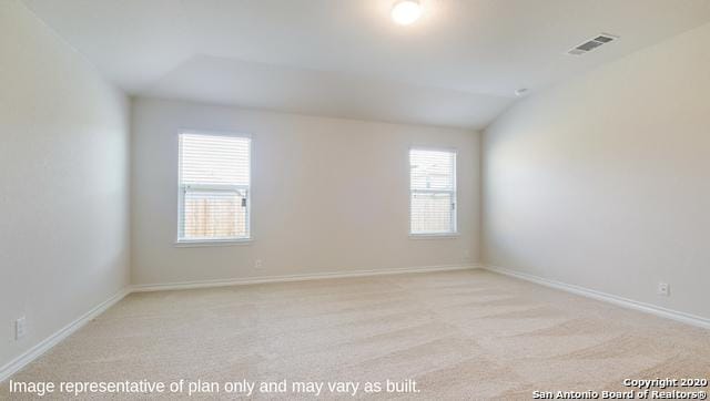 empty room with light carpet and lofted ceiling