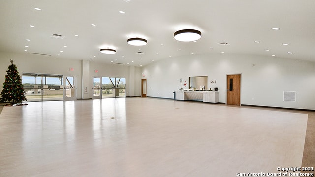 interior space with lofted ceiling and light hardwood / wood-style flooring