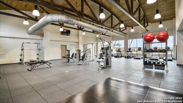 workout area featuring high vaulted ceiling and wooden ceiling