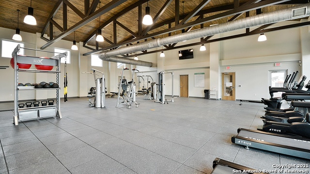 workout area with wood ceiling and high vaulted ceiling