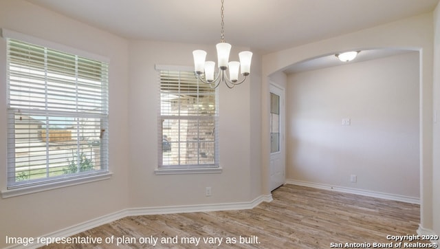 unfurnished dining area with light hardwood / wood-style flooring and a chandelier