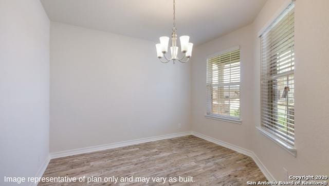 unfurnished room featuring light hardwood / wood-style flooring and a chandelier