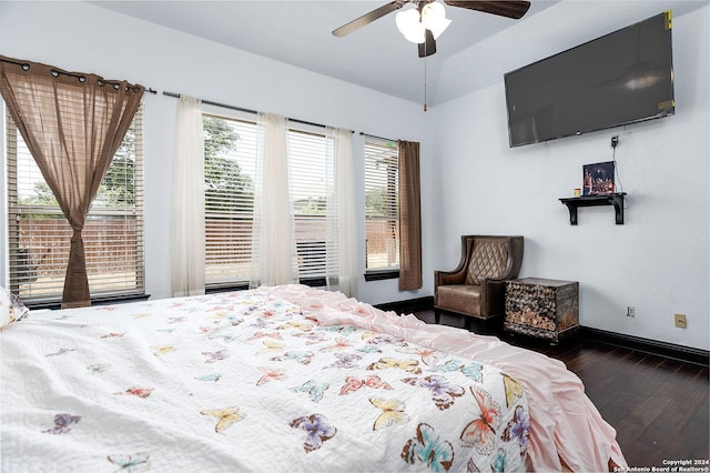 bedroom featuring ceiling fan, dark hardwood / wood-style flooring, and multiple windows