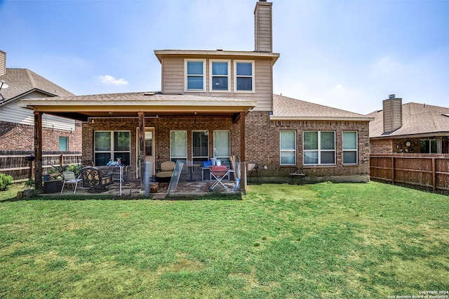 rear view of property featuring a patio and a yard