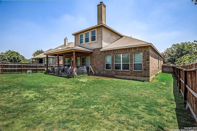 back of house with a yard and a patio area