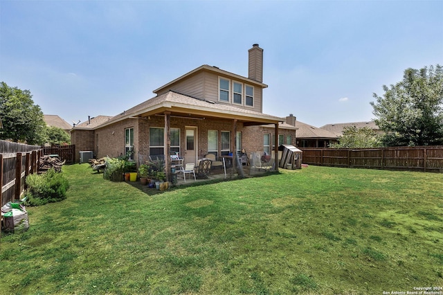 back of house featuring a patio area and a lawn