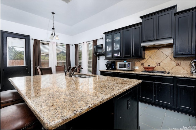 kitchen with sink, a center island with sink, a kitchen breakfast bar, pendant lighting, and stainless steel appliances