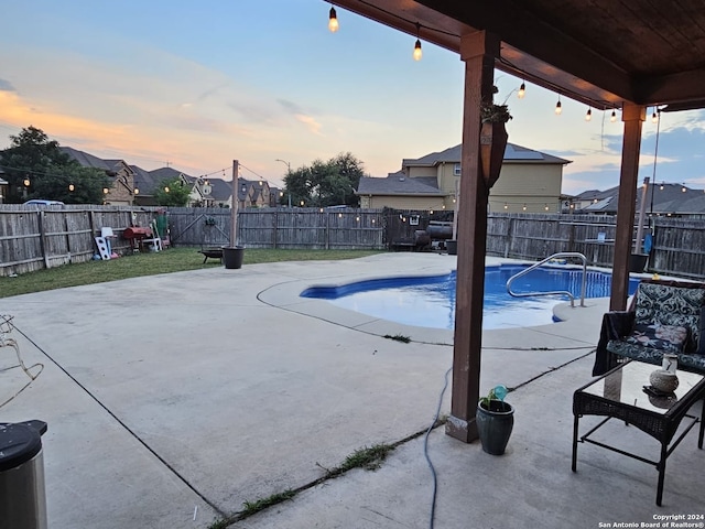 pool at dusk featuring a patio area