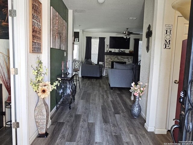 hallway with a textured ceiling and dark wood-type flooring