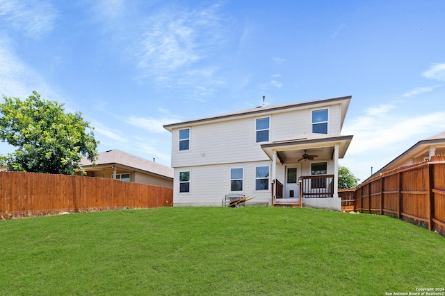 back of property with a lawn, ceiling fan, and covered porch