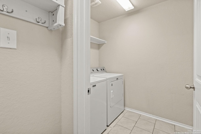 washroom with separate washer and dryer and light tile patterned floors